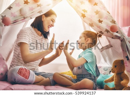 Happy loving family. Mother and her daughter girl play in children room. Funny mom and lovely child having fun indoors.  Royalty-Free Stock Photo #539924137