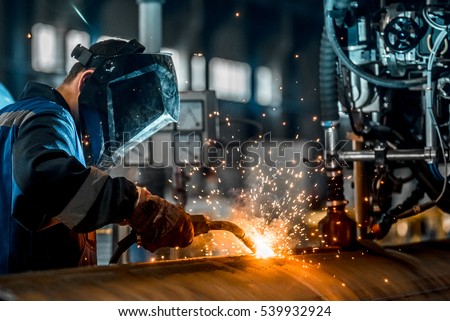 man welds at the factory Royalty-Free Stock Photo #539932924