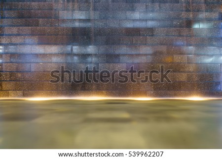 Waterfall at brick wall with smooth wave and light at bottom.Use for background or wallpaper.