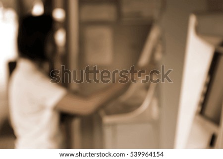 Blurred abstract background and can be illustration to article of woman inserting a credit card to ATM