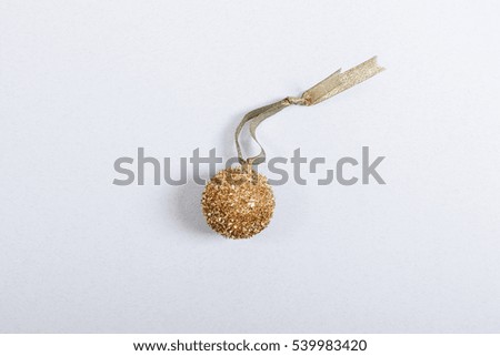 Golden Christmas ball with a ribbon on a blue background top view