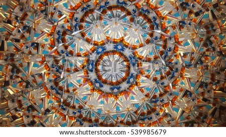 A live photo of a look through a kaleidoscope. Warm colors