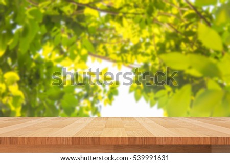 wood shelf on blurred green leaves background
