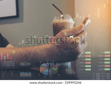 Man is using mobile phone while sitting in coffee shop checking stock data with chart and information overlay