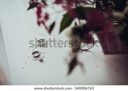 Wedding bouquet and rings on white table