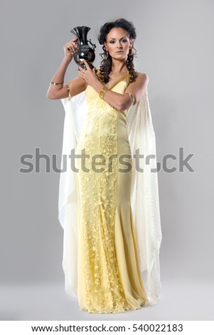 picture of beautiful woman in a dress of ancient Greece on a gray background