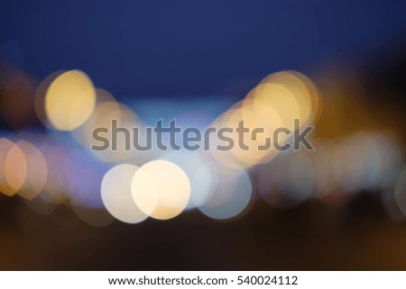 The evening street illumination. Multicolor bokeh lights on sky background. Bulbs at the night street building blurry motion. Warm and cold colors.