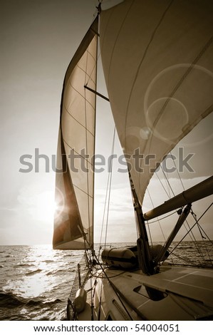 yacht sailing towards sunset - picture in sepia tone