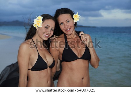 mother and daughter on the beach in hawaii at sunrise