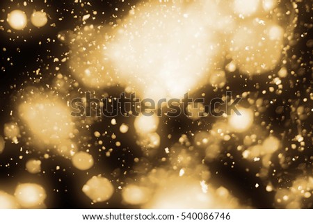 Golden abstract sparkles or glitter lights. Merry Christmas festive background.defocused circle bokeh or particles