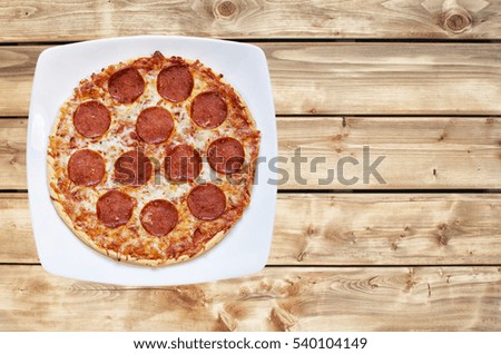 Pepperoni and cheese pizza on a wooden background with retro look