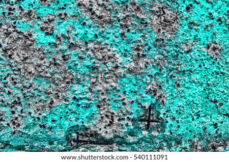 Fragment of  old grungy texture with chipped paint and cracks or  turquoise grey green concrete wall and cement surface with small stones and metallic elements, dirty 