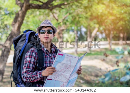 Young tourists with maps in the shade in the hot sun.