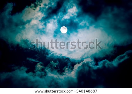 The moon on the dark sky among the clouds, natural blue abstract background