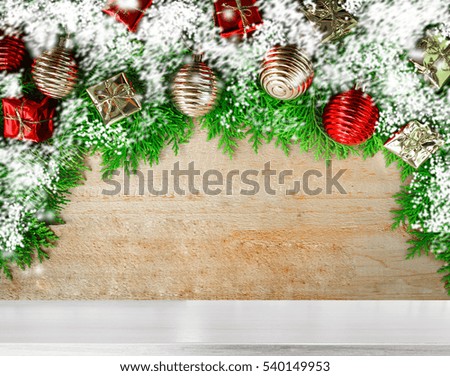 Wooden background with snow and ball box green leaves for texts display