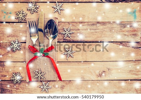 christmas table place setting and silverware, snowflakes with snow winter on table wooden background