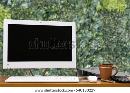 PC monitor on the table Natural green background.copy space