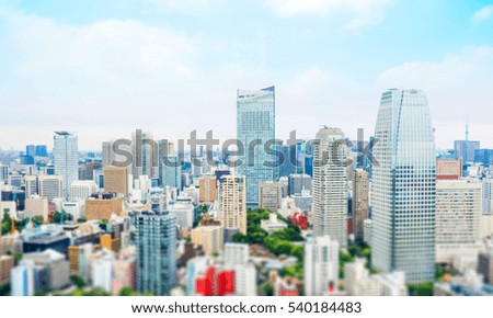 Business and culture concept - panoramic modern city skyline bird eye aerial view from tokyo tower under dramatic morning blue cloudy sky in Tokyo, Japan. Miniature Tilt-shift effect