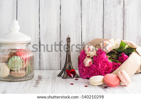 French macaroons cookies and flowers over white wooden background. Mothers day or Valentines day greeting card