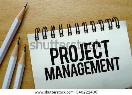 Project Management text written on a notebook with pencils