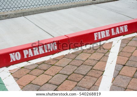 Painted red curb with no parking and fire lane