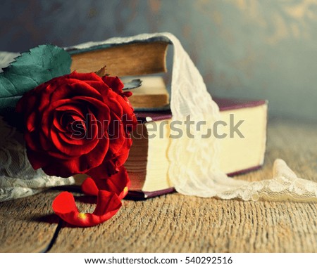 Red rose on an old book in a vintage style