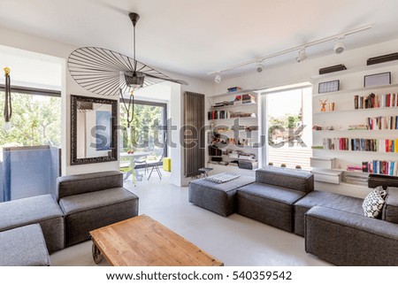 Bright living room with couch, table and many books on the shelf