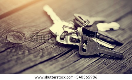 Bunch of keys lies on a wooden table. Royalty-Free Stock Photo #540365986