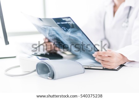 Woman Doctor Looking at X-Ray Radiography in patient's Room Royalty-Free Stock Photo #540375238