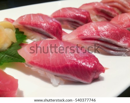Japanese nigiri sushi with pickled ginger, red hamachi fish, selective focus on front