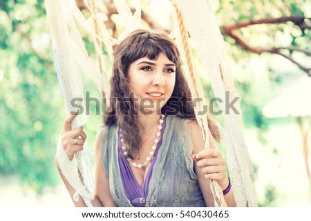 Girl in vintage style on a rustic swing decorated with lace, summer in Provence