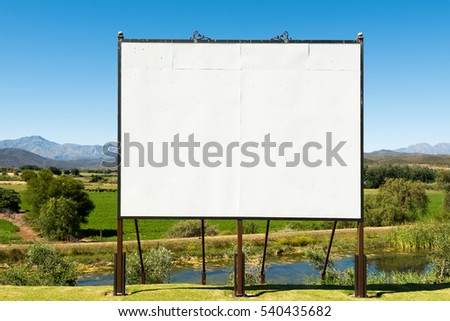 Big blank billboard in a nice scenery along the Garden Route of South Africa. The billboard is hand made, you can see the various boards and screws that could still shine through the image you place