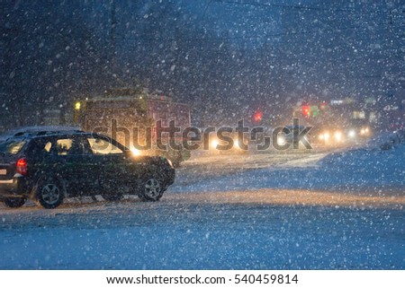 Traffic in the city in evening during heavy snowfall  picture with shallow depth of field. 