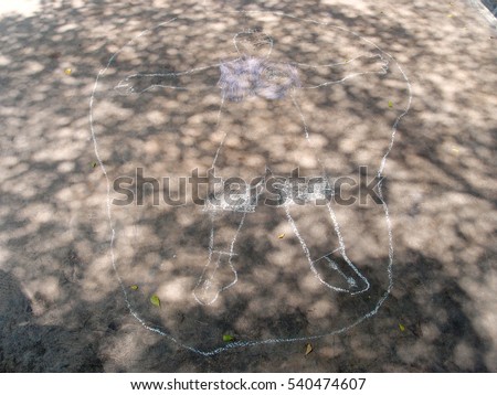 color chalk paint / doodle on the ground by 5 years old kid and have shadow of trees on picture.