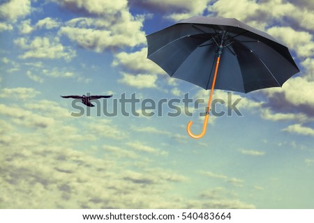 Mary Poppins Umbrella.Black umbrella flies in dramatic sky.Wind of change concept. Royalty-Free Stock Photo #540483664