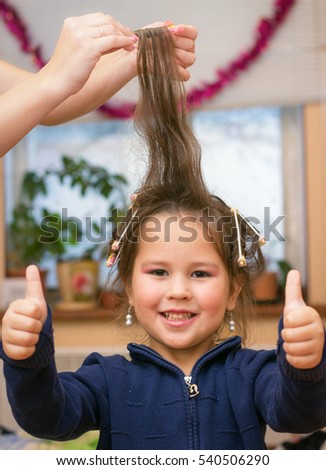 little girl makes a hairstyle. twists curlers
