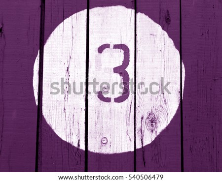 Number three on wooden magenta toned wall. Numbers and figures.