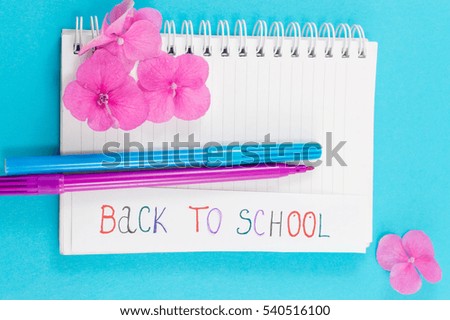 Color pens on top of notebook and back to school note