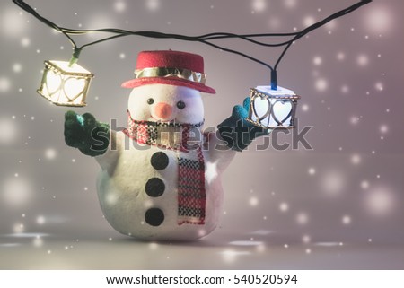 Snowman and light bulb stand on white background. Snow flake is falling down. Decoration gift for Merry Christmas and happy new year