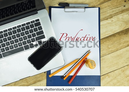 Productive text word in notepad with wooden background, texture and notebook in a table.