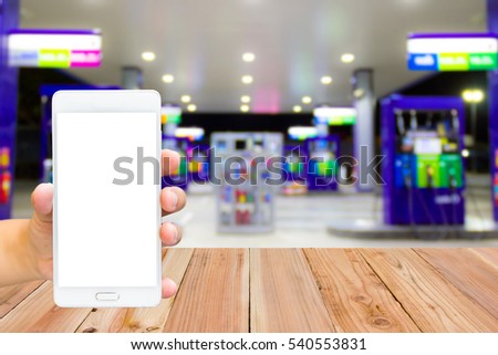 Man use mobile phone, blur image of inside gas station as background.