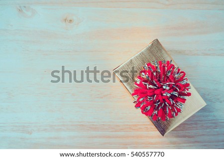 golden gift box on wood table for christmas background