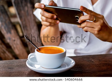Taking photo of the coffee with mobile phone