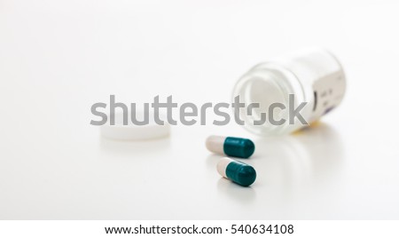 Capsules out of a bottle on white background