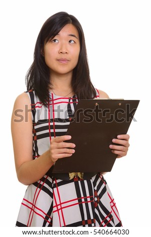 Young beautiful Asian businesswoman holding clipboard while thinking isolated against white background