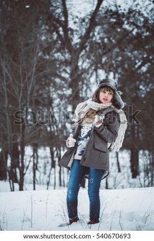 Beautiful young girl walking in winter forest.