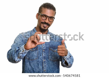 Young happy Indian man smiling and taking picture with mobile phone while giving thumb up isolated against white background
