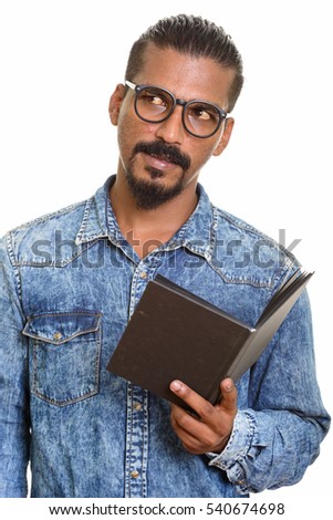 Young Indian man reading book while thinking isolated against white background