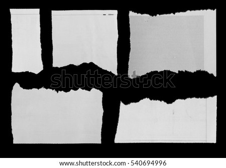 Pieces of torn paper on black