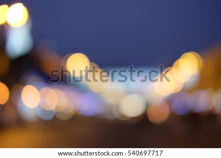 Blurry motion. Multicolor defocused bokeh lights on sky background. Lamps at the night street. Colors: blue, yellow, violet. Blurry light